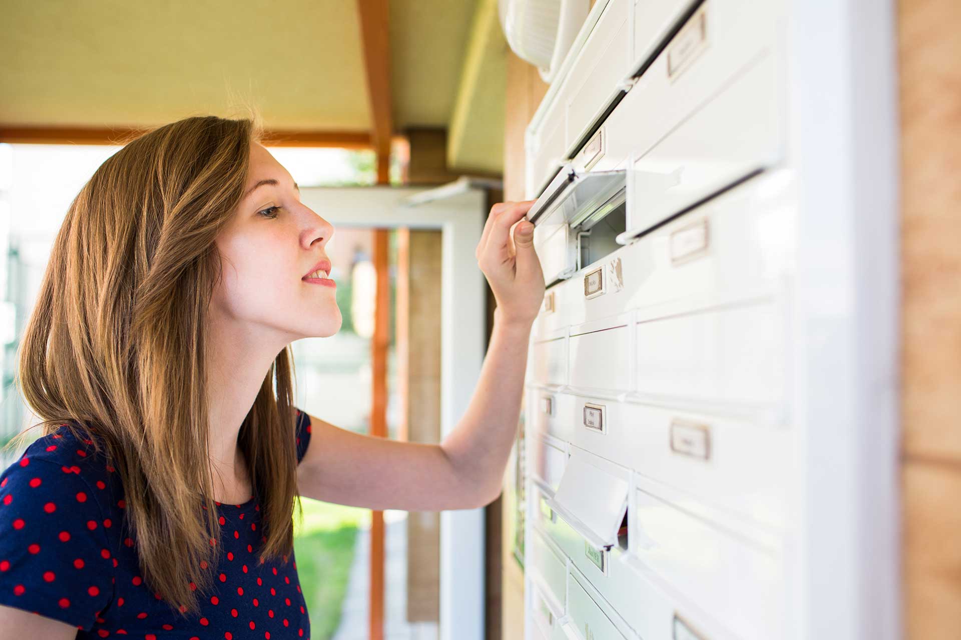 Pretty, young woman checking her mailbox for new letters Effektive Werbung mit Postwurf: Flyerverteilung & mehr in Wien und Umgebung